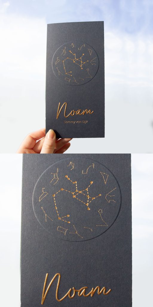 De moeder van Noam heeft dit bijzondere kaartje vormgegeven. Het sterrenbeeld staat hier centraal en is mooi uitgewerkt met koperfolie en een opwaartse preeg op donkerblauw papier.